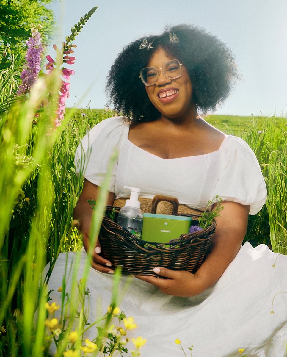 Woman holding a basket with Blueland products in a field of flowers