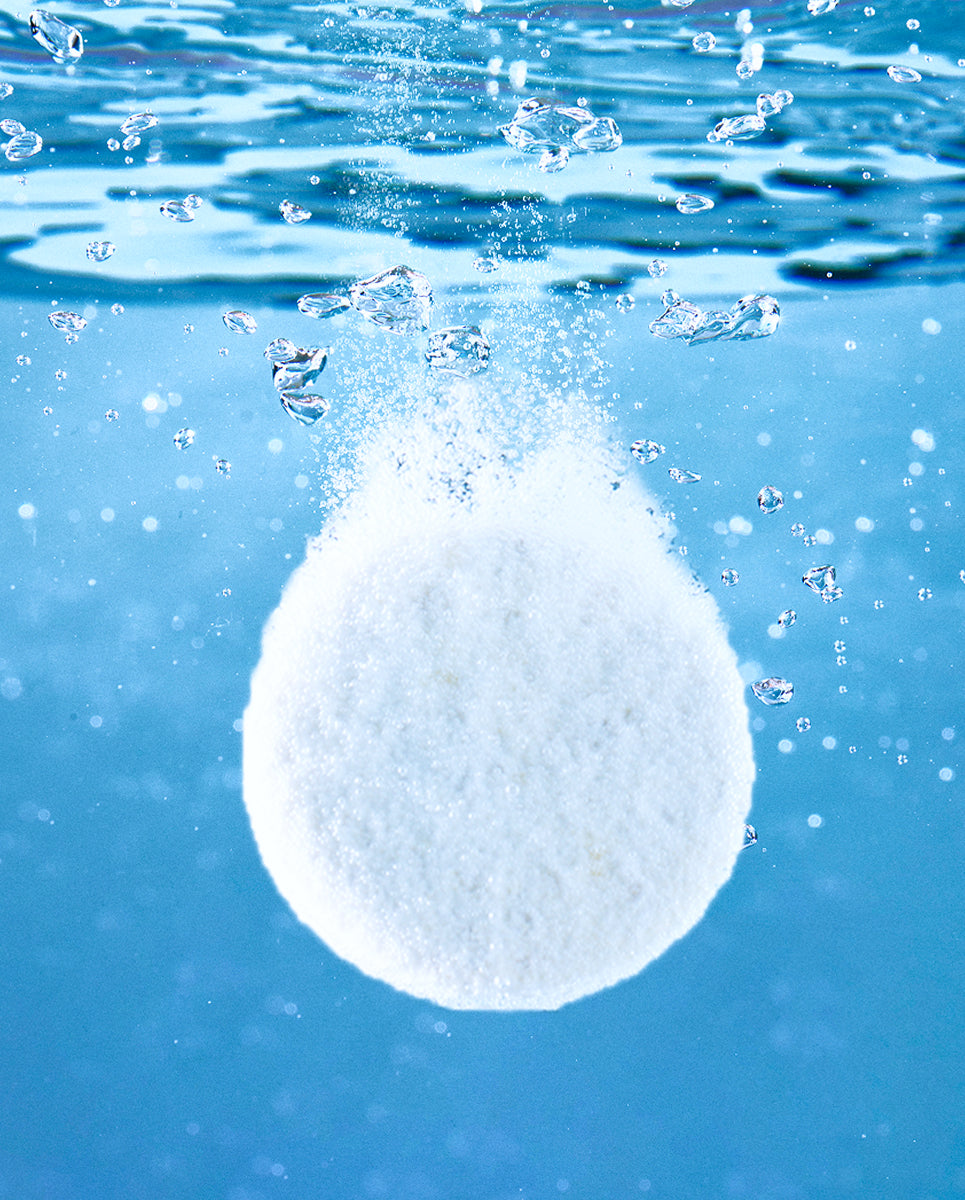 cleaning tablet dissolving in clear blue water